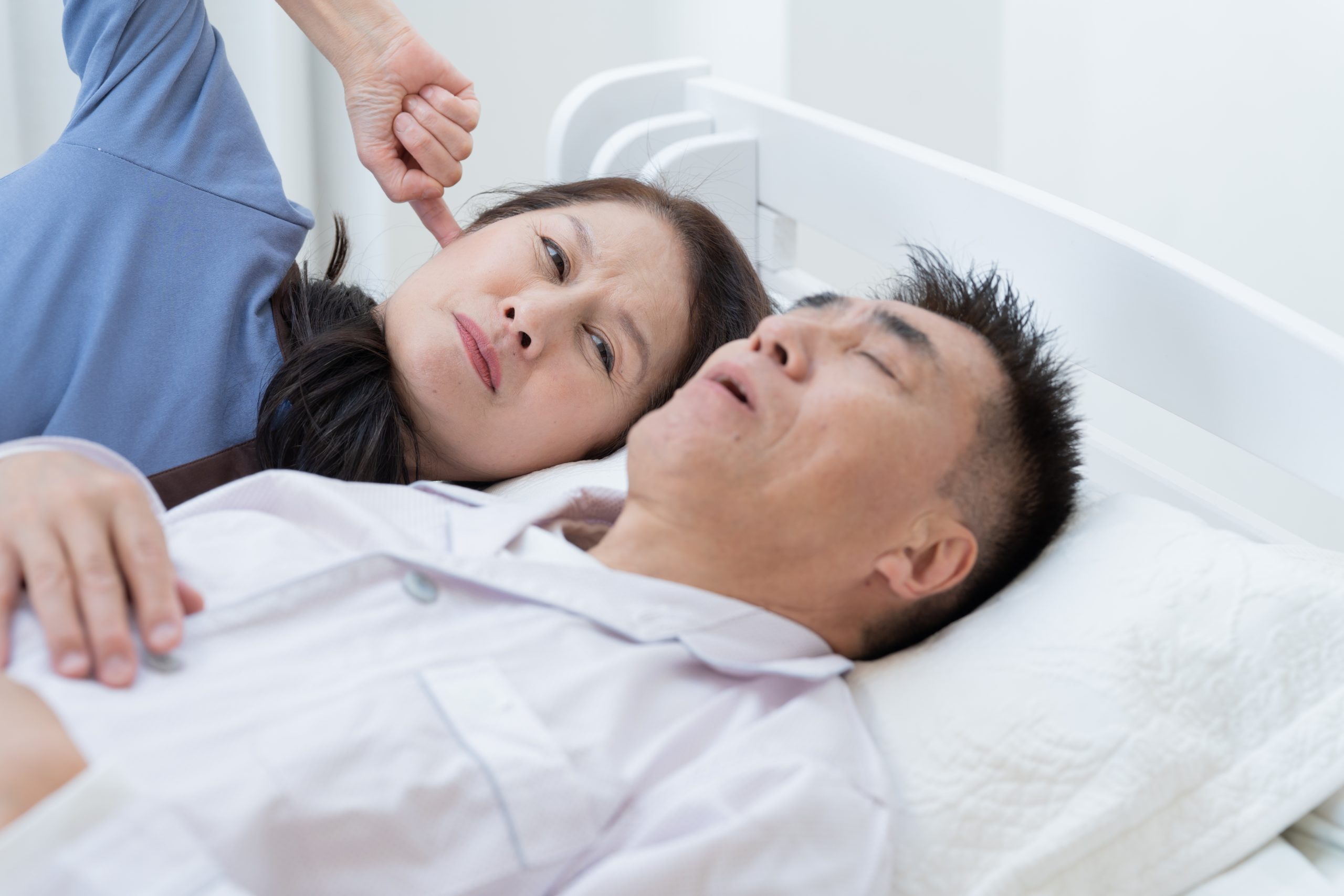 いびきを男性と耳をふさぐ女性